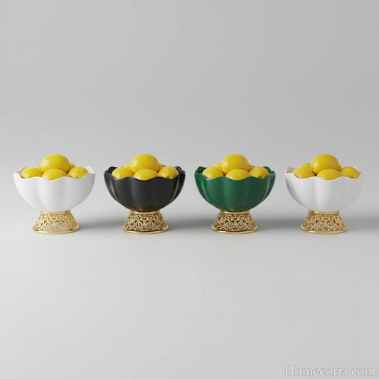 Set of decorative fruit bowls with gold and black bases on a gray background.
