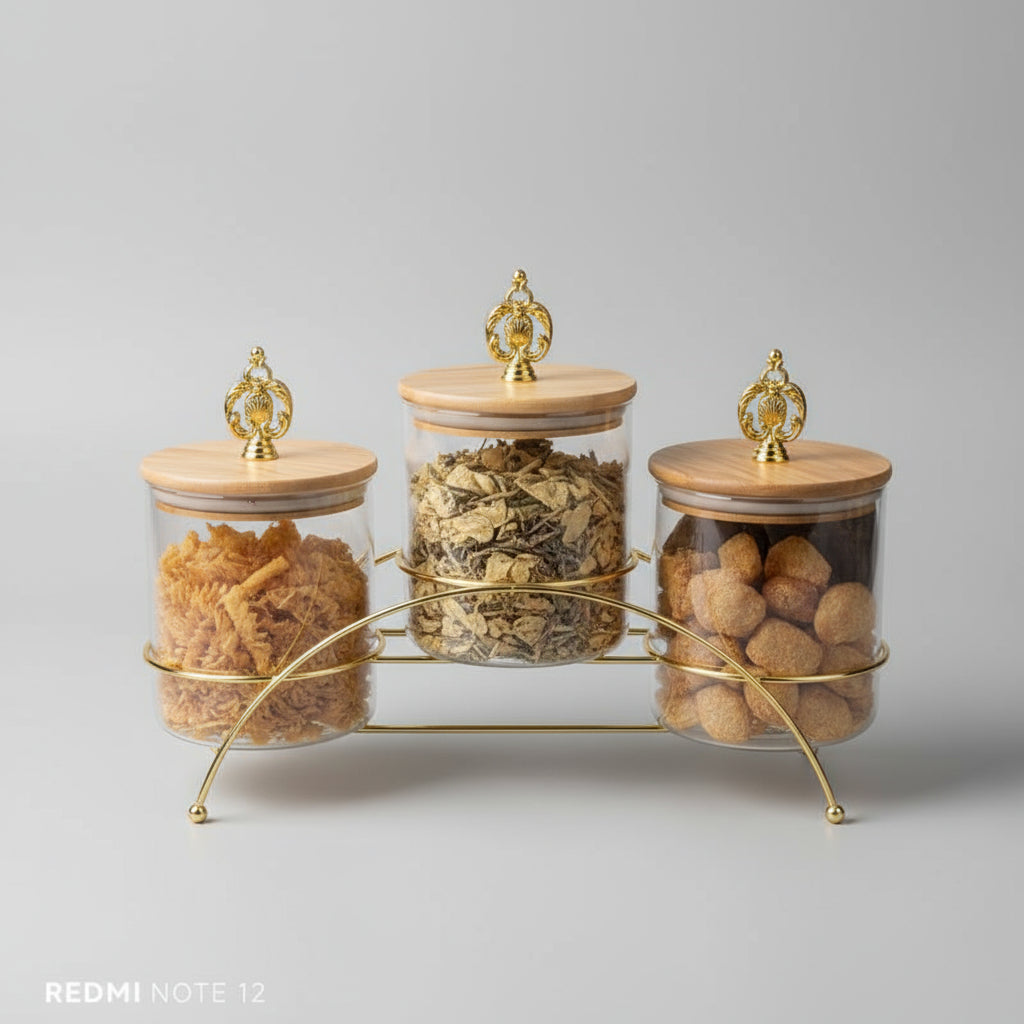 Set of luxury metal glass storage jars with a decorative stand on an orange box background.